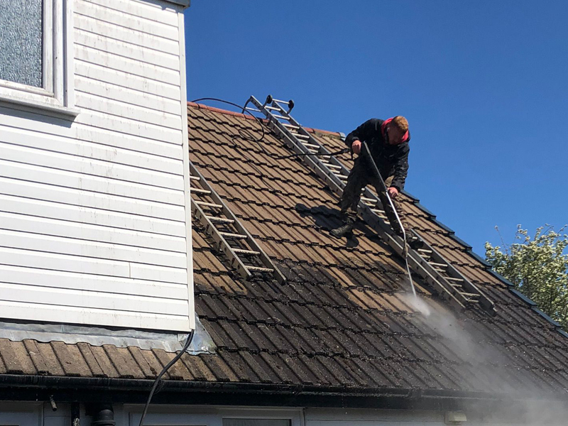 Professional roof cleaning in action